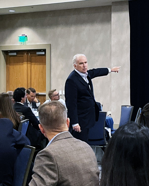 man in suit pointing to presentation